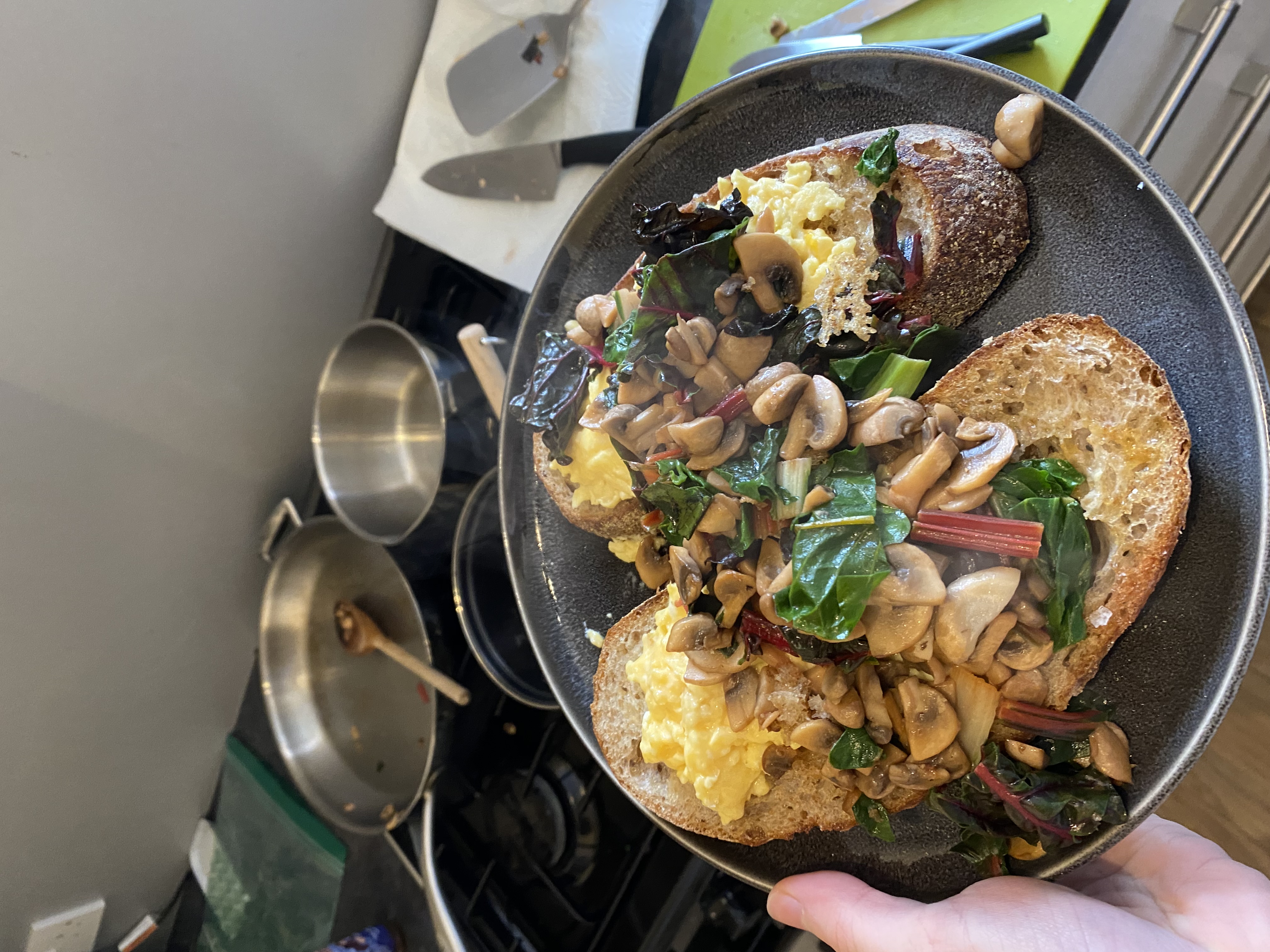A picture of scrambled egg on toast with sautéed rainbow chard and mushrooms
